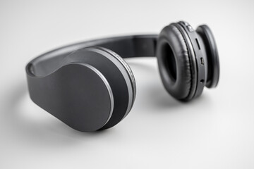 Gray wireless headphones on gray background.