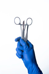 doctor wearing gloves holding surgical scissors, forceps and scalpel