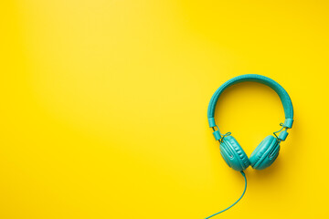 Colorful wired headphones on yellow background