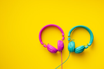 Colorful wired headphones on yellow background