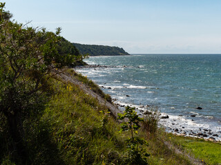 Beautiful green nature coastline at the baltic sea in northern Germany. Mecklenburg-Vorpommern landscape at Cape Arkona with the Baltic Sea. A blue summer sky is in the background. Idyllic scenery