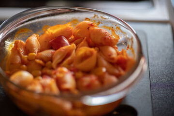 Close up and selective focus on a pasta bake straight out of the oven with intentional shallow depth of field and bokeh