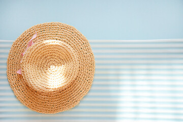 straw hat with blue background and white linen with copy space,  top view, flat lay