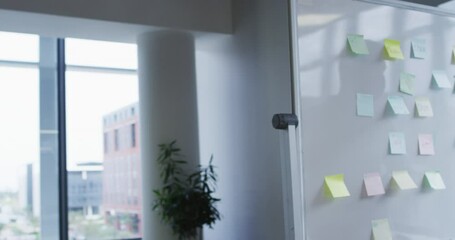 Diverse male creative colleagues wearing face masks brainstorming and working in busy office - Powered by Adobe