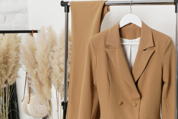 Corner in fashion atelier with fashionable tailored blazer hanging on a rack. Modern premium...