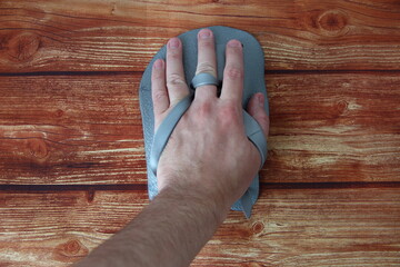 Hand in swimming paddle on wooden background