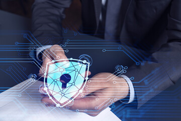 A programmer is browsing the Internet in smart phone to protect a cyber security from hacker attacks and save clients confidential data. Padlock Hologram icons over the typing hands. Formal wear.