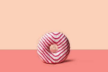 Fototapeta na wymiar Epilation concept - donut with hair on a pink background