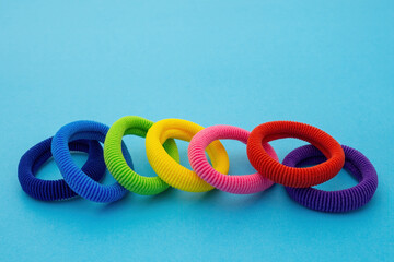Scrunchies, Colored elastic baby hair ties, cotton hair kids ponytail holders, seamless hair bands on blue background