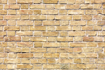 The wall is made of very old brick, all cracked, scratched and stained.