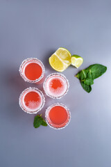set of four pink cocktails with lime and mint top view