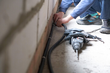 Construction worker drilling hole Repair in house