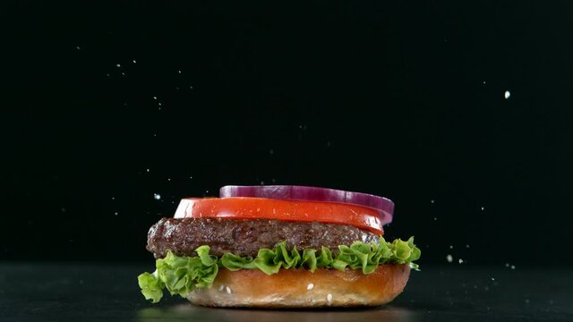 Super slow motion of stacking hamburger pieces on black background. Filmed on high speed cinema camera, 1000 fps.