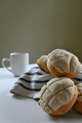 closeup of homemade Mexican vanilla shells with white and blue cotton dishcloth and white mug with handle on dark background and white surface