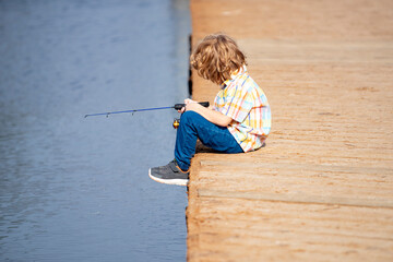 Fishing concept. Child fishing on the lake. Young fisher. Boy with spinner at river. Portrait of...