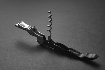 Opened sommelier knife with corkscrew and bottle opener, professional waiter knife, on black background - obrazy, fototapety, plakaty