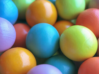 Background from multicolored bright small wooden balls of blue, yellow, red, lilac and green colors. A beautiful summer bright background for your projects..