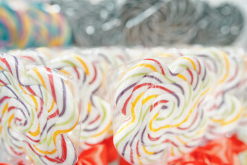 Coloured lollipops on stick on shop window. Caramel snacks on sale. Sweet candies dessert for kids.