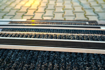 Closeup of ceramic tiles covering porch stairs with rubber anti slippery stripes on it.