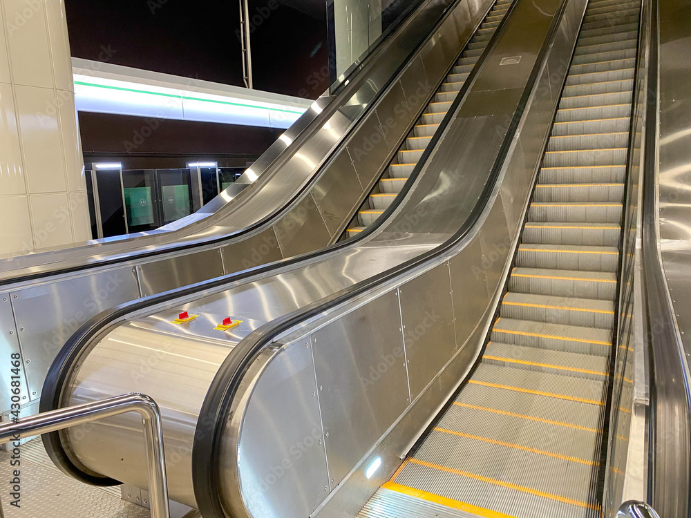 Poster large comfortable fast metal modern escalators with automatic steps for going up and down the subway