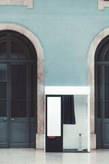 Vertical shot of an indoor empty photo booth with open curtain, in between two wooden arch doors...