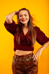 young pretty woman posing in fashion style on yellow background, lifestyle people concept