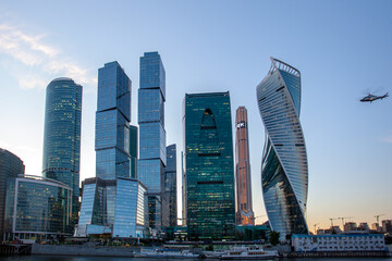 Moscow City - evening view of skyscrapers Moscow International Business Center. There is a helicopter in the sky.