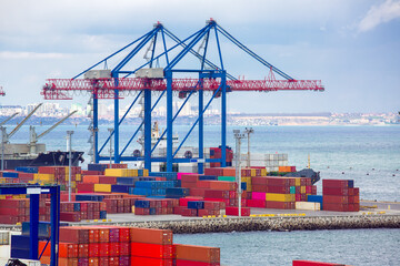 Fototapeta premium port with cranes for loading containers into ships for the delivery of goods for export by sea.