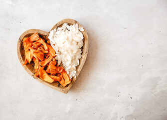 Dried fruit - mango and coconut on a wooden plate. Copy Space. Superfoods, vegan, vegetarian snacks.
