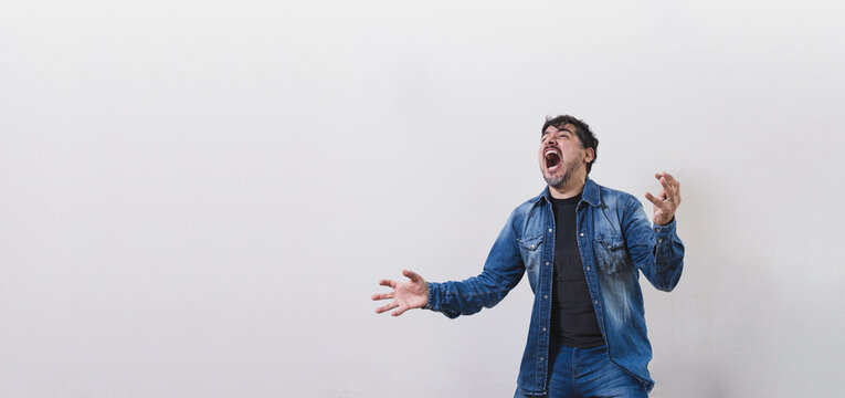 Retrato panor&aacute;mico de hombre violento, encolerizado, muy enojado, gritando desesperado sobre pared blanca