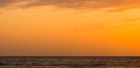 Fototapeta na wymiar Amazing sea sunset on the pebble beach, the sun, waves, clouds