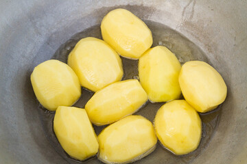 Golden potatoes are fried in boiling oil in a cauldron