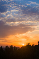Landscape with dramatic light - beautiful golden sunset with saturated sky and clouds.