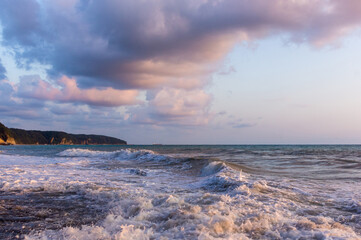 sea landscape is a pebbly beach with waves in white foam