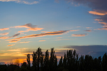 Landscape with dramatic light - beautiful golden sunset with saturated sky and clouds.