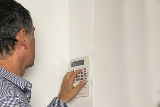 Man operating on an alarm keypad