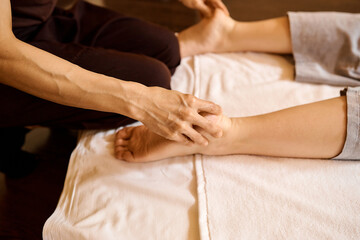 Obraz na płótnie Canvas woman's hands do foot massage in beauty salon office