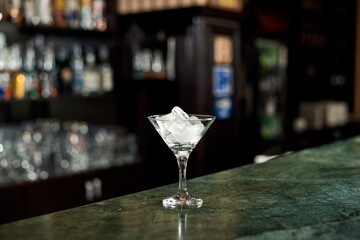 
a glass of ice is on the bar