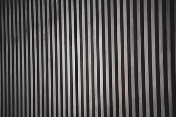 Obraz premium Vertical striped, dark metallic texture of the building.