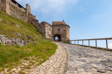 A stone-paved road leads to the gates of an ancient knight's castle