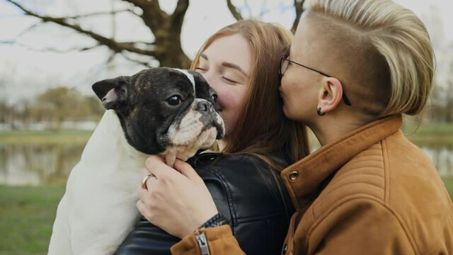 Cute lesbian couple hugging their happy dog