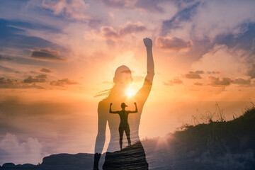 Strong confident woman on mountain top flexing arms facing the sunset. People feeling inspire, and...