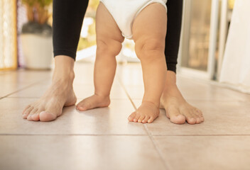 Closeup of mother baby's feet standing. 