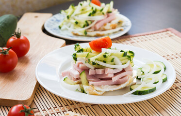 Breakfast. Salad with fried eggs, ham, cucumber, onion, tomatoes