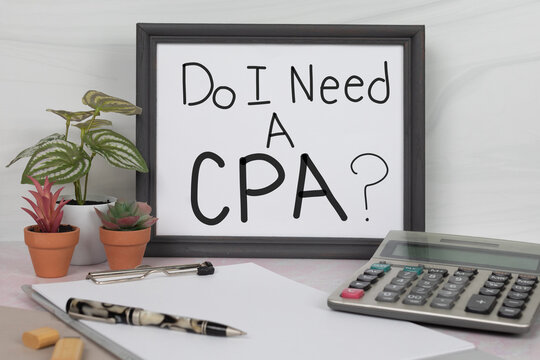 Do I need a CPA sign in gray office desk picture frame with calculator pen clipboard accounting work space no people