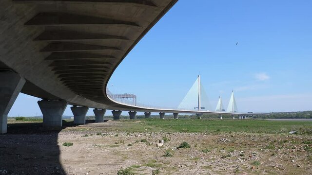 Low angle view of the long curve of toll Mersey Gateway Bridge between Runcorn and Widnes in Northwest of England.