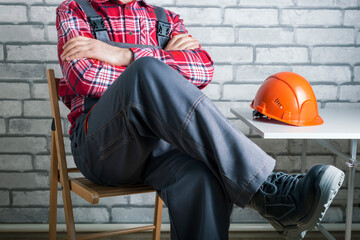 Striking worker on workplace. Worker on strike against brick wall background. Work refusal concept.