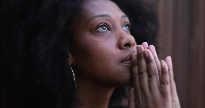 Hopeful African woman praying to God seeking FAITH and HOPE