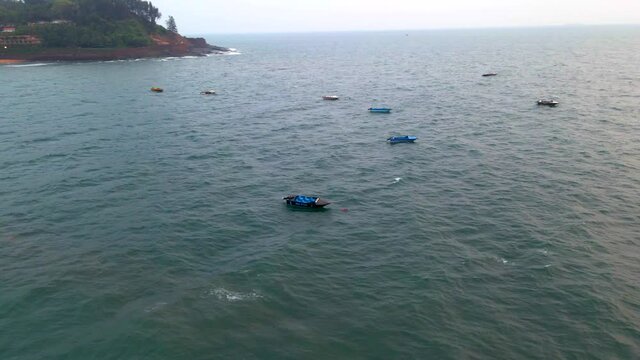 goa Sinquerim Candolim Beach drone bird's eye view boats floating over seawater beach in goa drone orbital shot