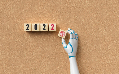 robot hand adding a cube with a goal symbol to other cubes with message 2022 as a concept for...